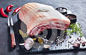 Raw pork belly with skin on a slate tray