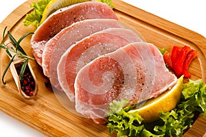 Raw pork chops on cutting board