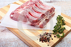 Raw pork chops, spices and rosemary on cutting board. Ready for cooking.