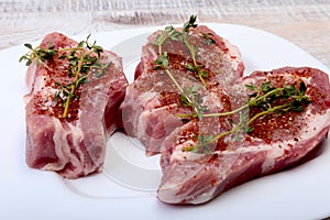 Raw pork chops, spices and rosemary on cutting board. Ready for cooking.