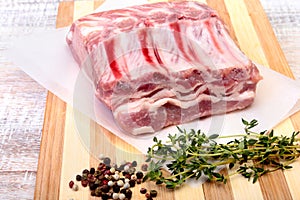 Raw pork chops, spices and rosemary on cutting board. Ready for cooking.