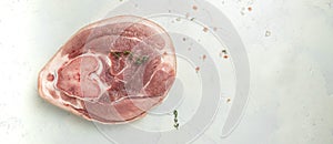 Raw pork ham cut on a wooden board. Leg meat on a light background, Culinary cooking. Long banner format. top view