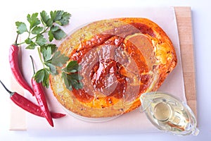 Raw Pork ham with spices, parsley leaves and chilli ready for BBQ grilling isolated on white background.