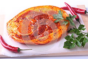 Raw Pork ham with spices, parsley leaves and chilli ready for BBQ grilling isolated on white background.
