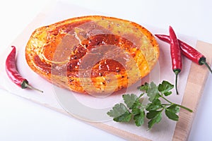 Raw Pork ham with spices, parsley leaves and chilli ready for BBQ grilling isolated on white background.