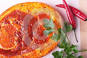 Raw Pork ham with spices, parsley leaves and chilli ready for BBQ grilling isolated on white background.