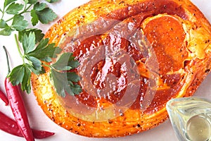 Raw Pork ham with spices, parsley leaves and chilli ready for BBQ grilling isolated on white background.