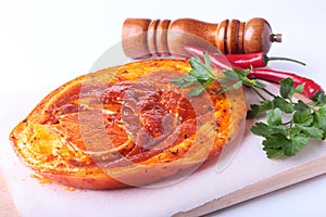Raw Pork ham with spices, parsley leaves, chilli and spice grinder ready for BBQ grilling isolated on white background.
