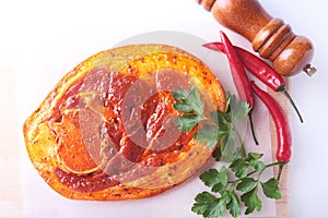 Raw Pork ham with spices, parsley leaves, chilli and spice grinder ready for BBQ grilling isolated on white background.