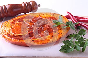 Raw Pork ham with spices, parsley leaves, chilli and spice grinder ready for BBQ grilling isolated on white background.