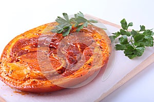 Raw Pork ham with spices and parsley leaves ready for BBQ grilling isolated on white background.