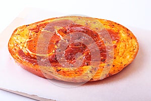 Raw Pork ham with spices and parsley leaves ready for BBQ grilling isolated on white background.