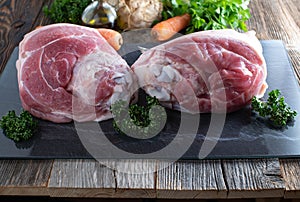Raw pork knuckle or ham hock on a cutting baord