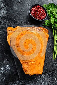 Raw pork leg with herbs and marinate on table. Black background. Top view