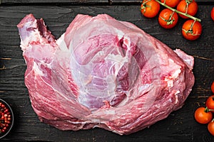 Raw pork meat with herbs, on black wooden table background, top view flat lay