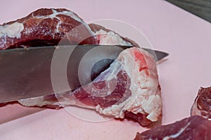 Raw pork meat with a knife on a cutting board. Preparation for cooking