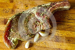 Raw pork meat with spices Leaves of coriander on wooden cutting board. Ready for cooking