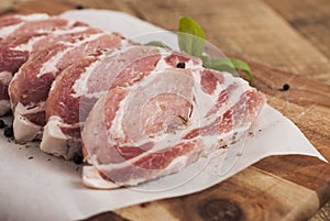 Raw pork meat with spices, wooden cutting board. Food Cooking Ingredient. Top view with copyspace.