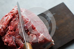 Raw pork meat on wooden background, cut with a knife