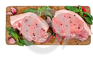 Raw pork meat on wooden cutting board with herbs and spices isolated on white background. cooking concept.