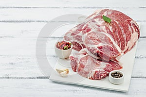 Raw pork neck meat. Traditional ingredients for cooking food. Garlic cloves, fresh parsley