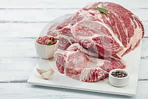 Raw pork neck meat. Traditional ingredients for cooking food. Garlic cloves, fresh parsley