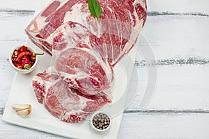 Raw pork neck meat. Traditional ingredients for cooking food. Garlic cloves, fresh parsley