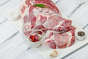 Raw pork neck meat. Traditional ingredients for cooking food. Garlic cloves, fresh parsley