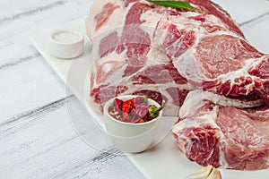 Raw pork neck meat. Traditional ingredients for cooking food. Garlic cloves, fresh parsley