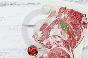 Raw pork neck meat. Traditional ingredients for cooking food. Garlic cloves, fresh parsley