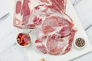 Raw pork neck meat. Traditional ingredients for cooking food. Garlic cloves, fresh parsley