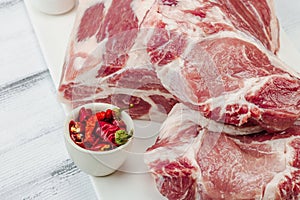 Raw pork neck meat. Traditional ingredients for cooking food. Garlic cloves, fresh parsley