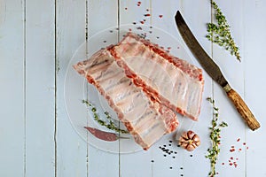 Raw pork ribs with herbs, garlic and pepper on white background