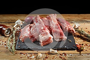 Raw pork ribs are laid out on a cutting board.Spices for cooking meat dishes close-up.Selective Focus.