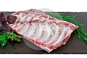 Raw pork ribs. Whole raw pork ribs on dark black background. Raw meat, farm and cooking concept. Meat shop