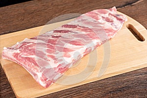 Raw pork ribs on a wooden cutting board.