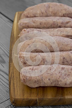 Raw pork sausages on a chopping board