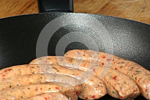 Raw pork sausages in a pan