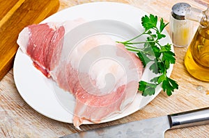 Raw pork secreto fillet and condiments prepared for roasting on plate