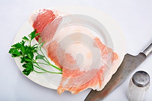 Raw pork secreto fillet and condiments prepared for roasting on plate