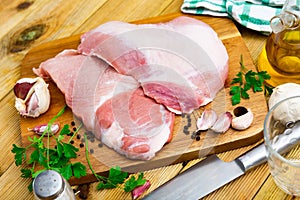 Raw pork secreto steak and spices prepared for cooking on wooden board photo