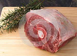 A raw pork shoulder with rosemary