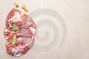 Raw pork shoulder with spices. Bay leaf, garlic. On a stone background