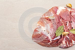 Raw pork shoulder with spices. Bay leaf, garlic. On a stone background