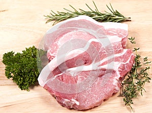 Raw pork steaks and herbs