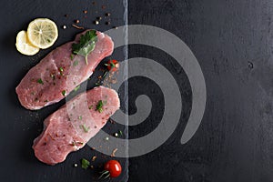 Raw pork steaks with spices and fresh vegetables.