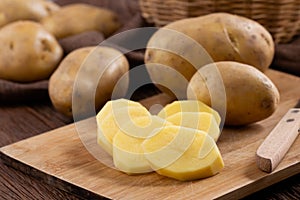 Raw potato sliced on board prepare for cooking, Fresh organic golden potatoes on wooden desk