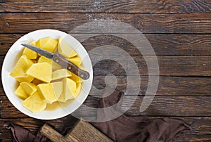 raw potato slices on rustic wooden kitchen table, top view