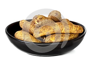 Raw Potatoes in Black Dish Isolated on White