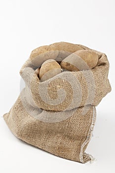 Raw potatoes in burlap bag